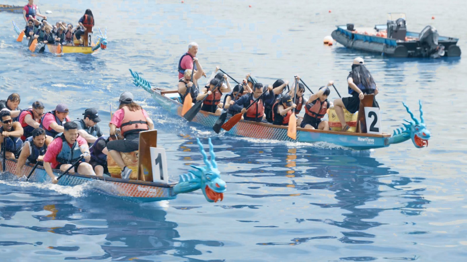 Two dragon boat crews racing side by side on the Royal Docks